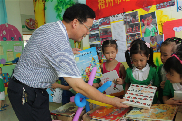 梧州市總工會黨組書記、常務(wù)副主席朱明勝在梧州市總工會到梧州高新區(qū)雙語實驗學校開展關(guān)愛農(nóng)民工留守活動中為孩子們送上學習用具